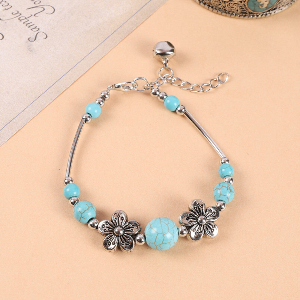 Silver discs spaced between turquoise beads, rich texture.