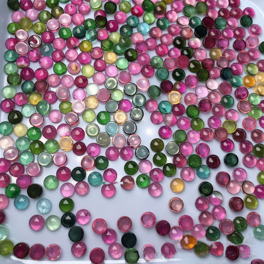 Loose round tourmaline stones, in various colors, are displayed in large quantities and are suitable for jewelry setting design.