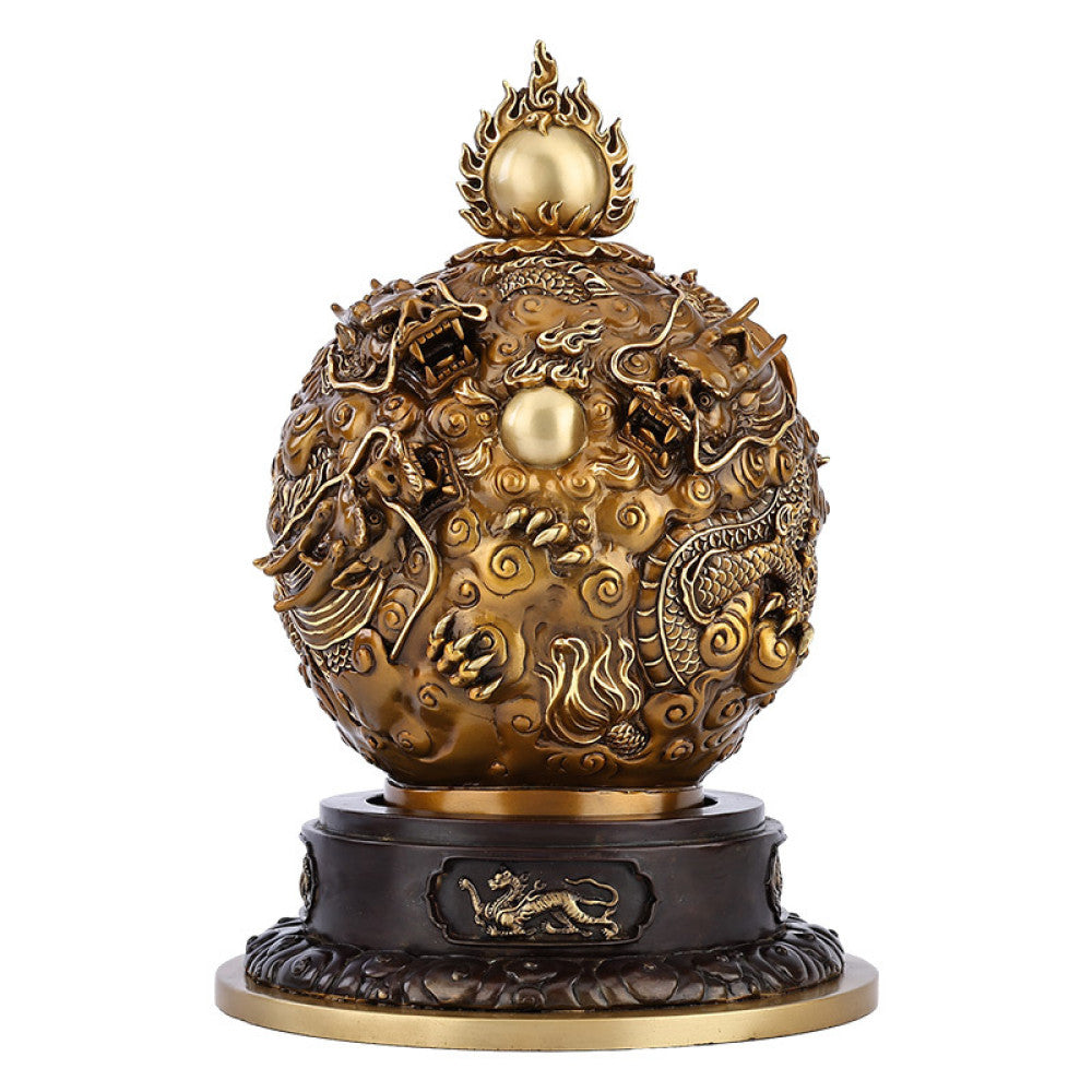Brass decorative ball statue with intricate dragon and cloud carvings, wooden base, against traditional Chinese patterned background on green surface 01