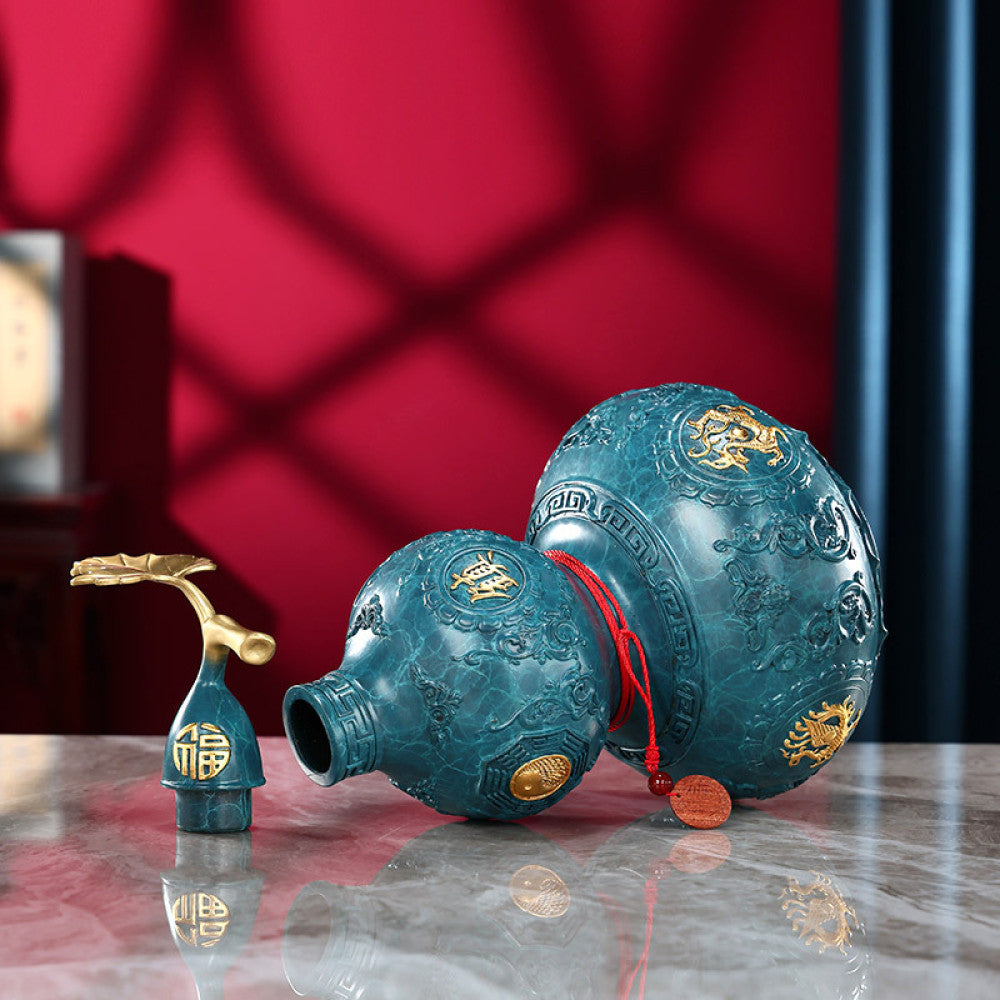 Blue-green brass gourd feng shui decor with golden dragon, "Fu" (fortune) characters, and red string, isolated on white background