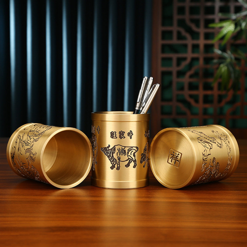 Three traditional Chinese brass pen holders with zodiac animal and Chinese character carvings, placed on a wooden table against a traditional interior background 01