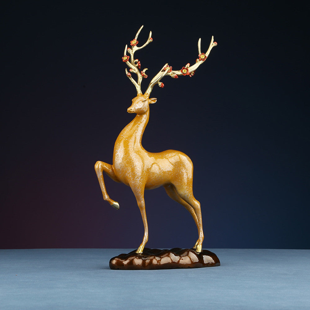 Golden traditional Chinese bronze deer statue with decorated antlers and raised leg, placed on a brown base against a dark gradient background