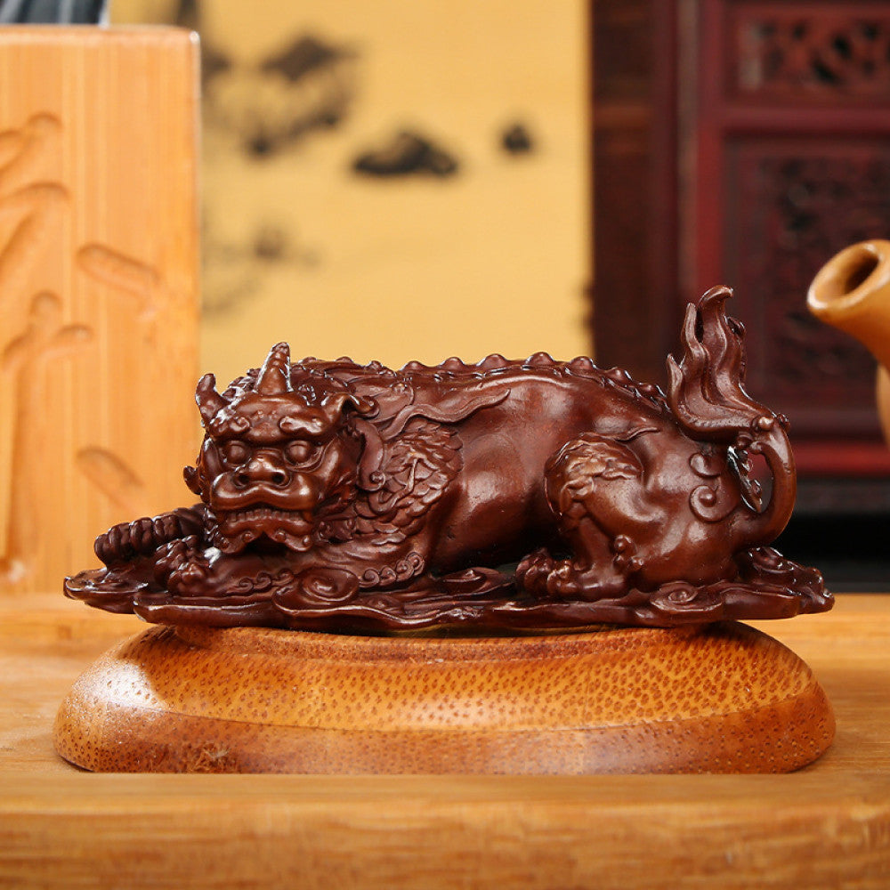 Traditional Chinese bronze mythical beast statue with intricate carvings, placed on a wooden surface against an ornate golden background 001