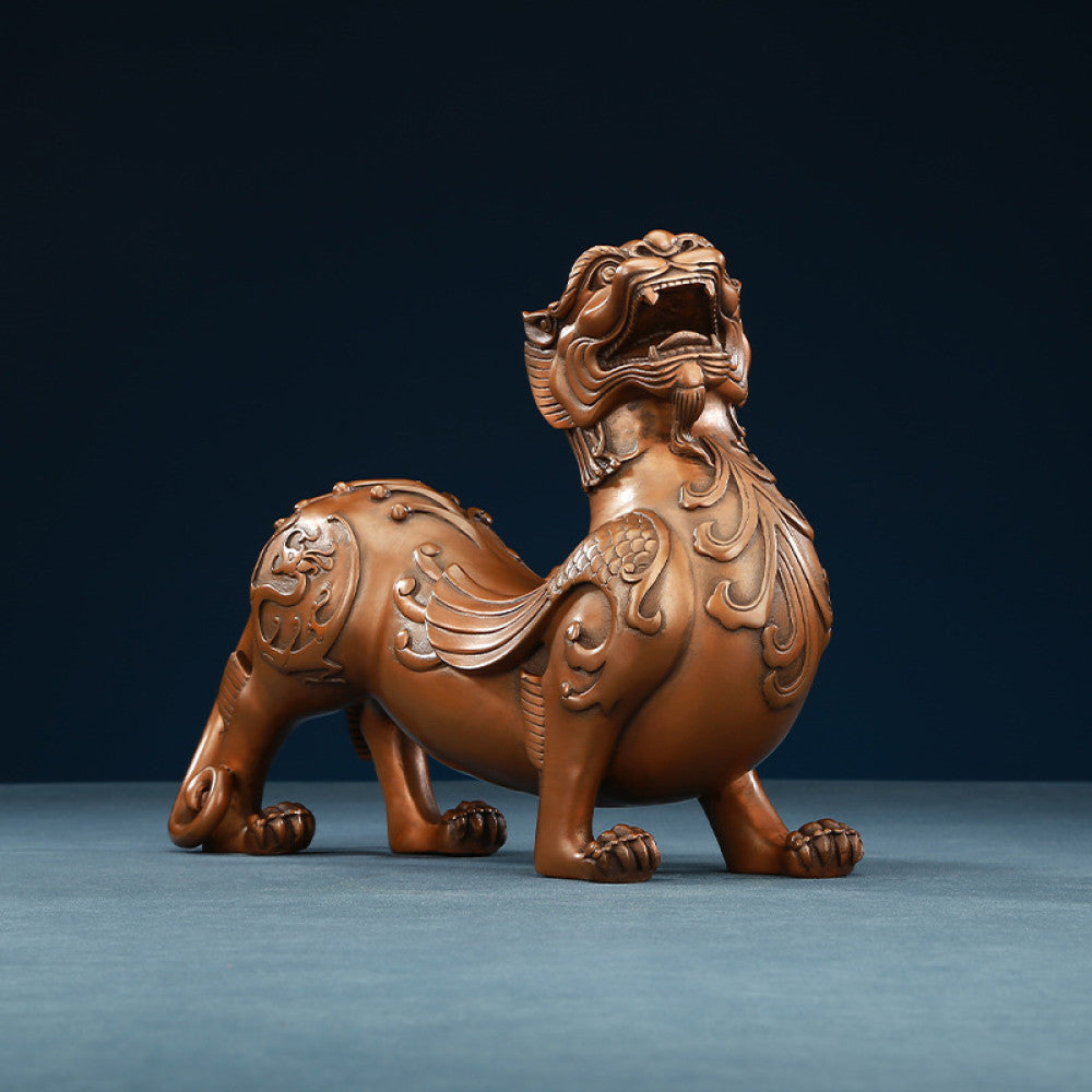 Traditional Chinese bronze Pixiu statue with intricate floral carvings, displayed against a dark blue background