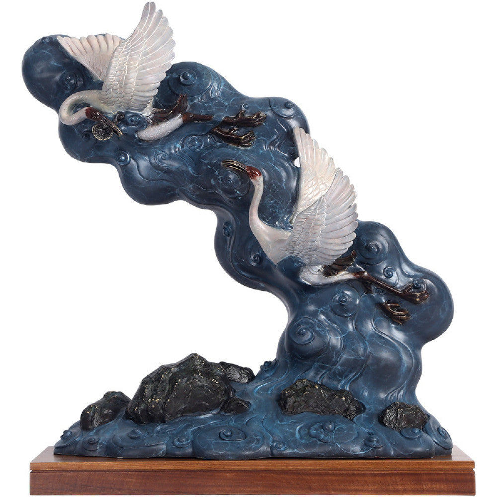 Traditional Chinese crane and cloud sculpture featuring blue clouds and white cranes, placed on a wooden base, isolated on a white background