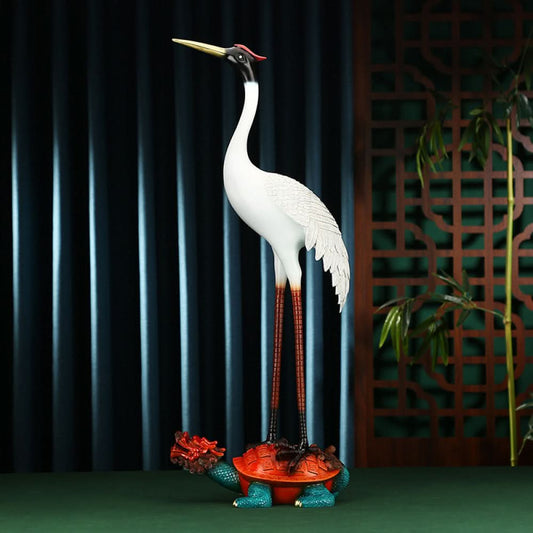 Traditional Chinese crane statue standing on a colorful tortoise, positioned against a dark screen with Chinese lattice pattern and bamboo in the background