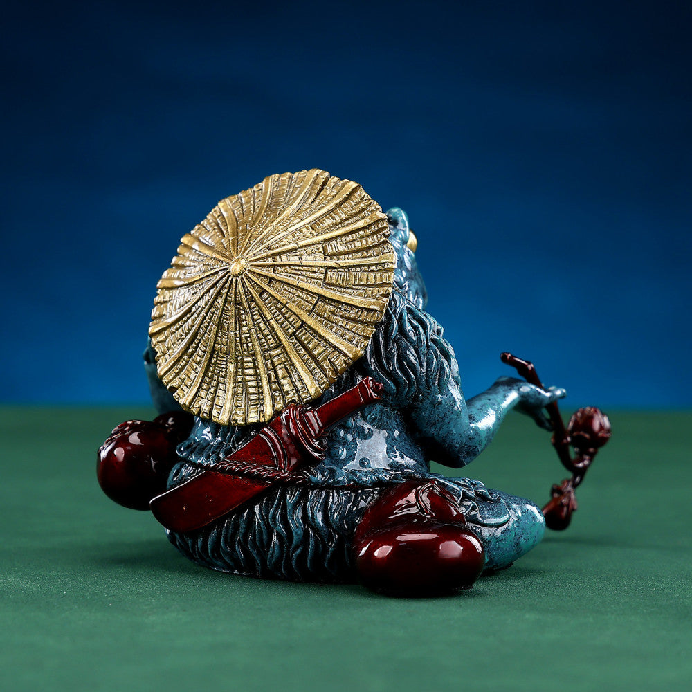 Colorful Chinese money toad statue with a straw hat, holding a ruyi - like ornament, placed on a green surface against a dark background 03