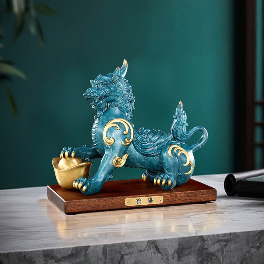 Traditional Chinese Feng Shui Pi Xiu statue in blue-green with gold inlay, holding a gold ingot, placed on a wooden base against a red background 01