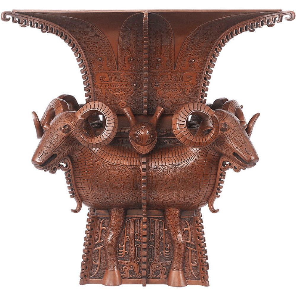 Traditional Chinese four - sheep bronze zun vessel with intricate carvings, isolated on white background
