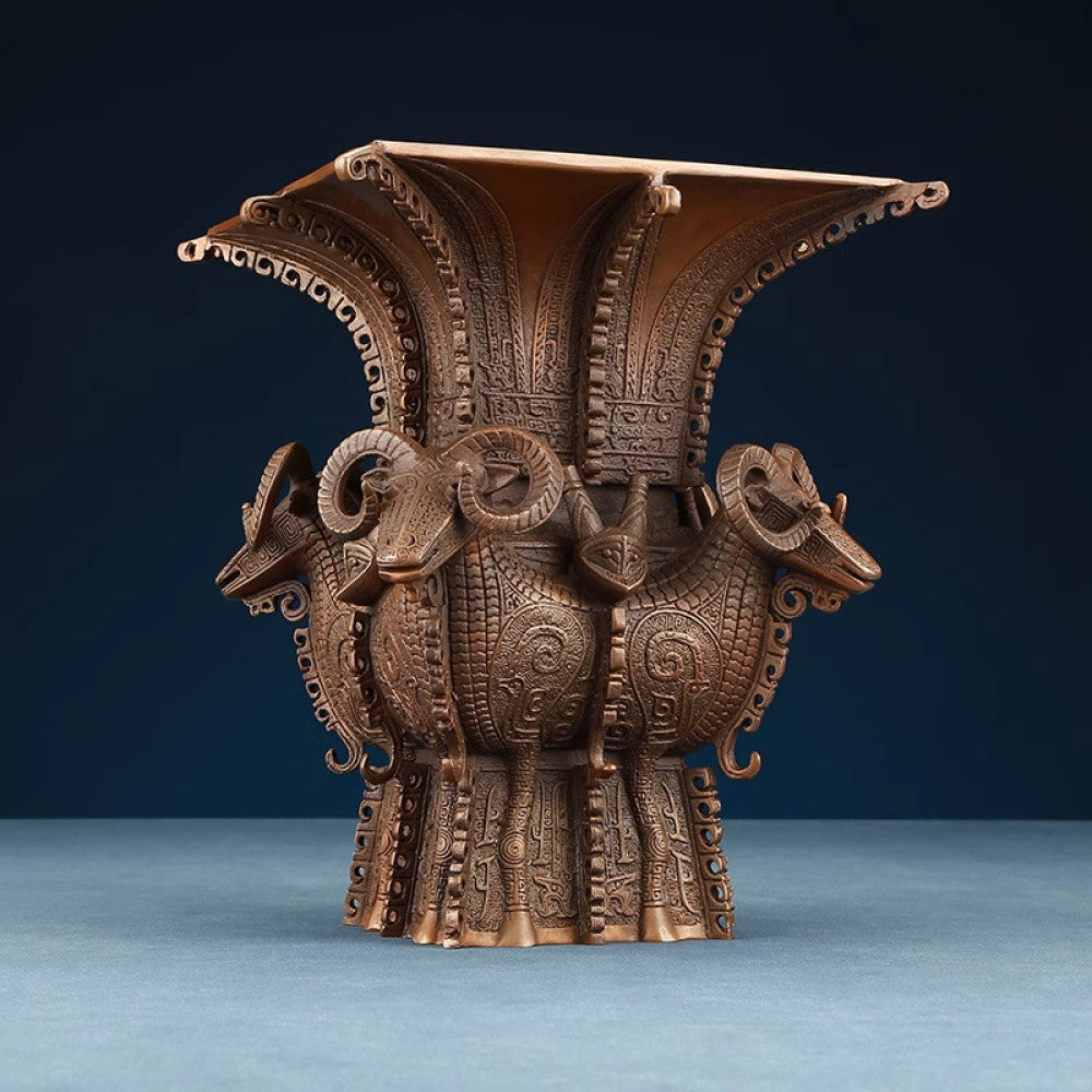 Traditional Chinese four - sheep bronze zun vessel with intricate carvings, isolated on white background