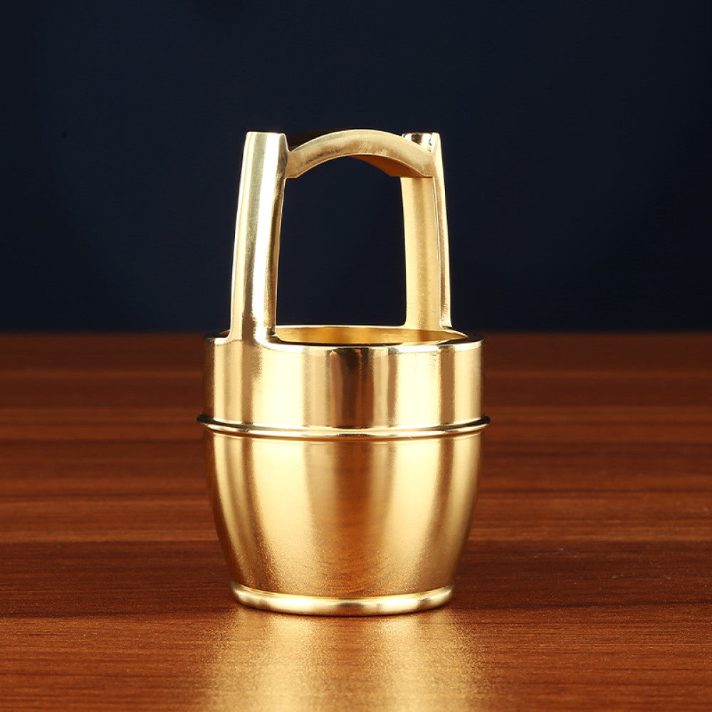 Golden brass handled teapot with lid placed on wooden table against dark background 01