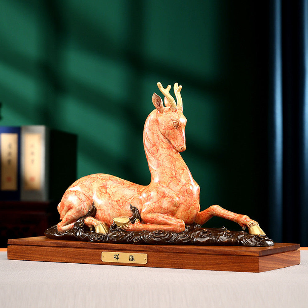 Traditional Chinese golden bronze deer statue in a reclining pose with detailed antlers, placed on a wooden base against a dark green background with traditional books 02