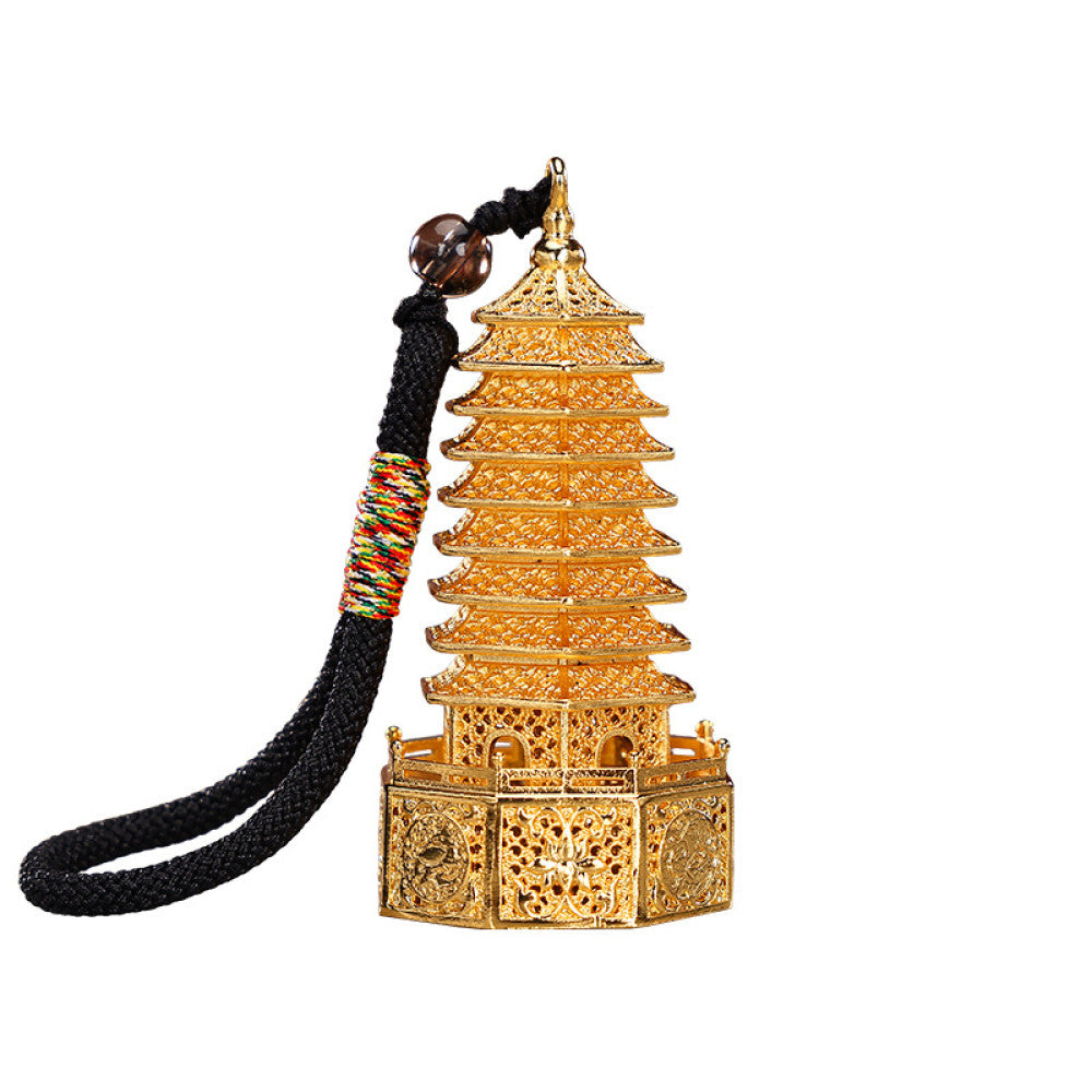 Golden Chinese Wenchang Tower pendant with intricate carvings, attached to a black cord with colorful details and beads, isolated on white background