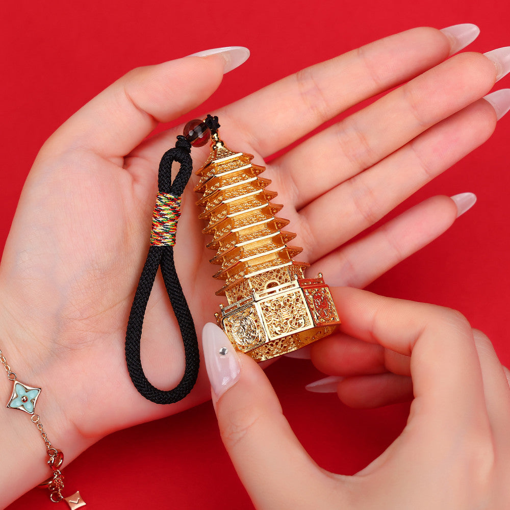 Golden Chinese Wenchang Tower pendant with intricate carvings, attached to a black cord with colorful details and beads, isolated on white background 03