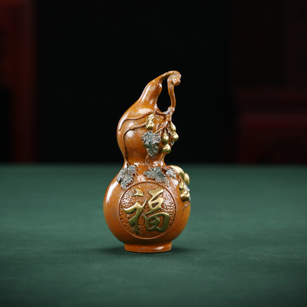 Traditional Chinese gourd statue with "Fu" luck character, colorful enamel details, placed on green surface against dark background