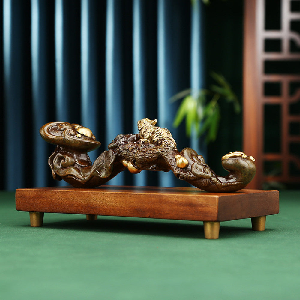 Traditional Chinese ruyi sculpture with golden pixiu and pearl details, placed on wooden base against dark blue curtain and traditional lattice background