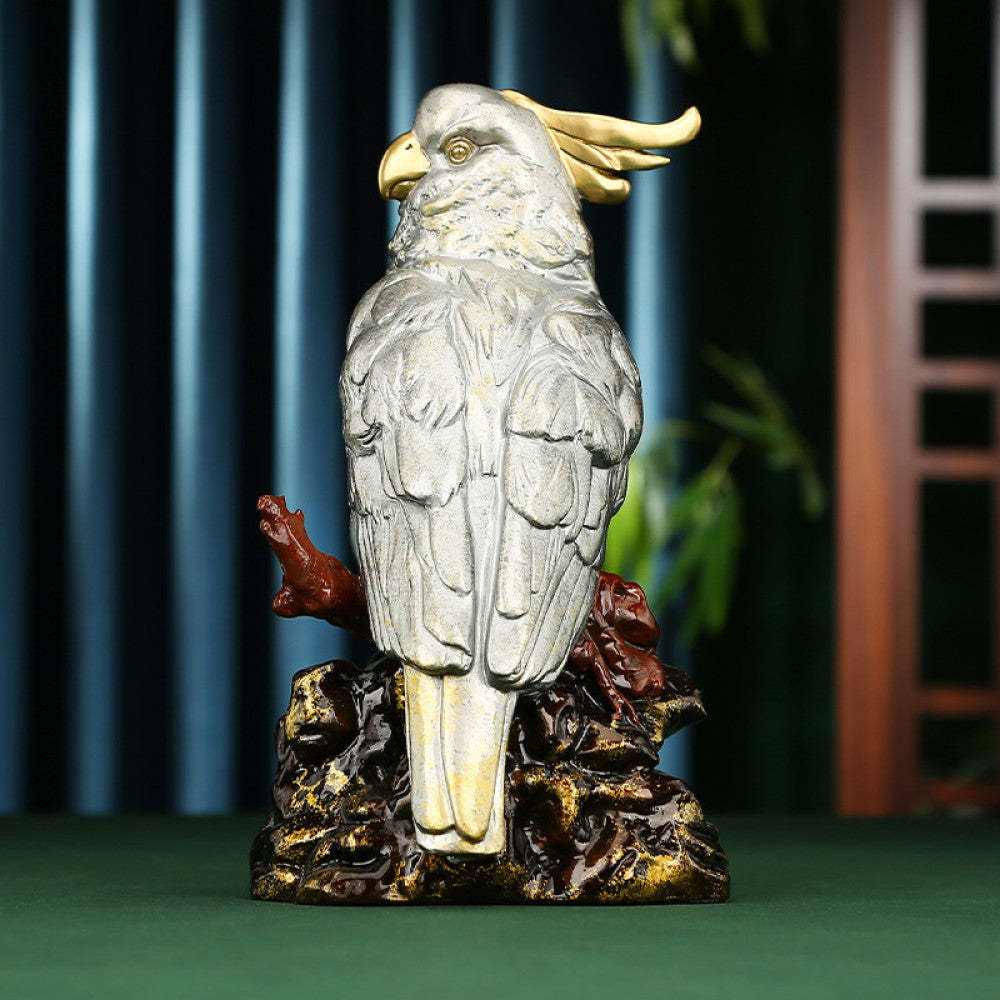 Traditional Chinese silver parrot statue with detailed feathers, perched on a golden - brown rocky base, set against a dark blue curtain and Chinese lattice background 01