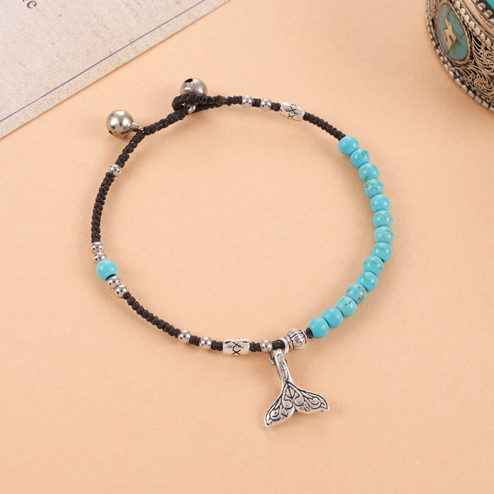 Turquoise beads with fish tail charm, fresh ocean vibe.