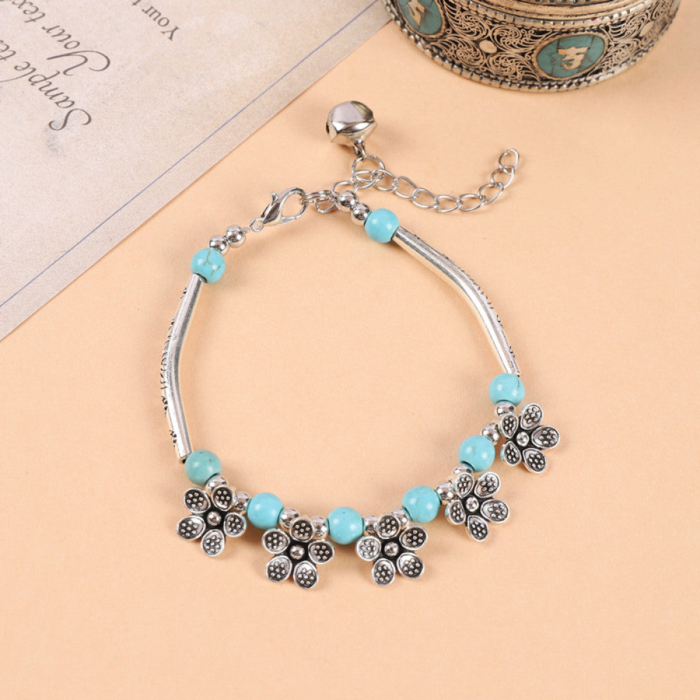 Multiple turquoise beads with tassel charms, playful movement.