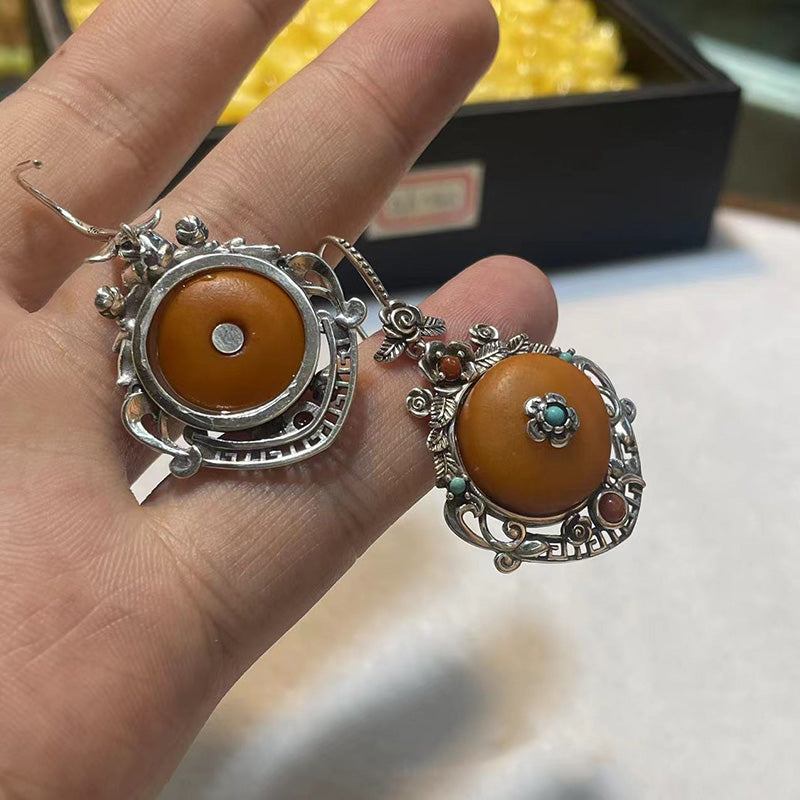 Unique asymmetrical silver-mounted antique amber earrings with colorful beads paired with silver jewelry to showcase a distinctive style