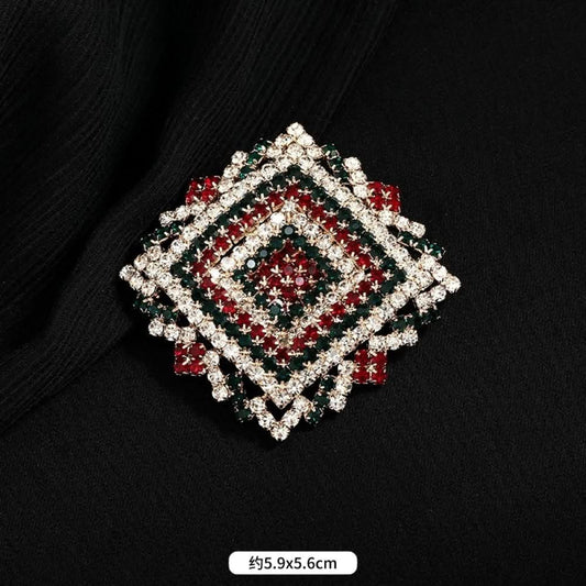 This ornate multi-layer floral brooch features vibrant red and green gemstones set in a clear crystal frame, adding a touch of vintage glamour to any outfit. Measures approx. 5x5cm 01