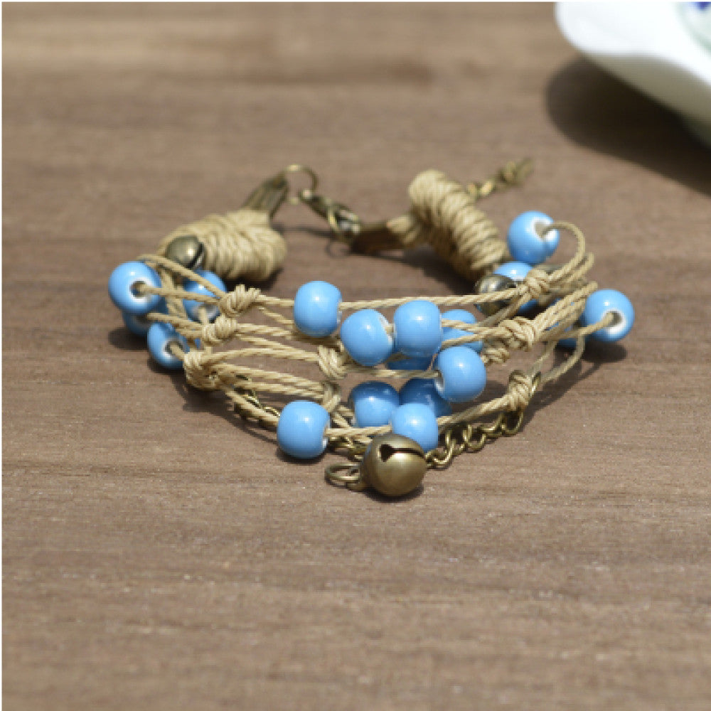 This bohemian multi-layer bracelet features vibrant ceramic beads woven on natural rope