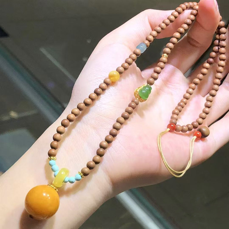 A charming necklace crafted with wooden beads, adorned with various gemstone accents like turquoise, green jade - like stones, yellow beads, and red beads. Features a prominent large amber pendant, complemented by gold - toned metal elements, making it a perfect piece for adding a touch of natural elegance to any outfit.