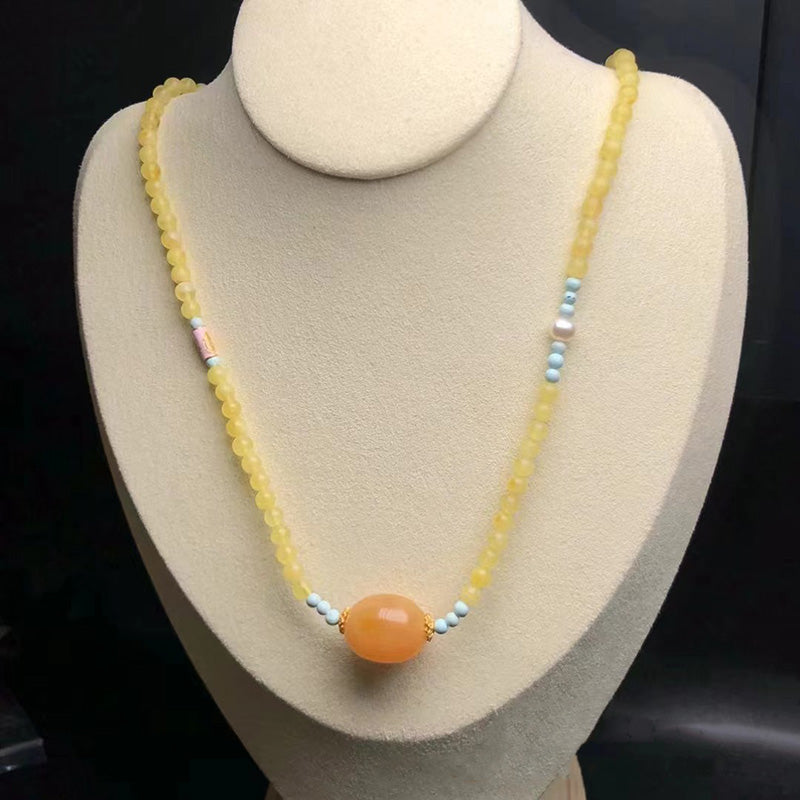 A beautiful necklace featuring a large, warm - toned amber bead as the centerpiece, surrounded by yellow amber beads. Delicate turquoise beads and small pearls are interspersed, adding a touch of charm and elegance. Ideal for those who love natural gemstone jewelry.