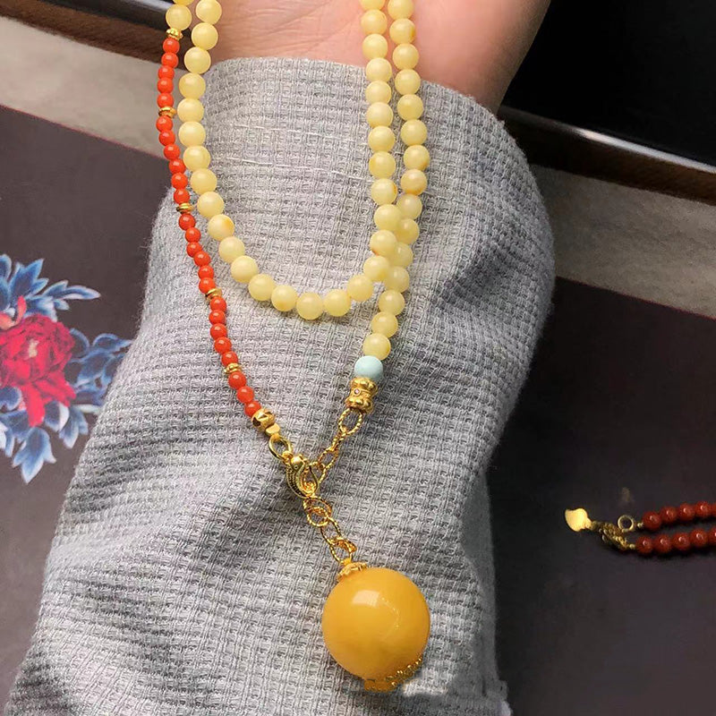 A beautiful necklace featuring a large yellow amber pendant, complemented by yellow amber bead chains, red South Red Agate beads, and a small turquoise bead. Gold - toned accessories add a touch of luxury. Ideal for those who love natural gemstone jewelry.