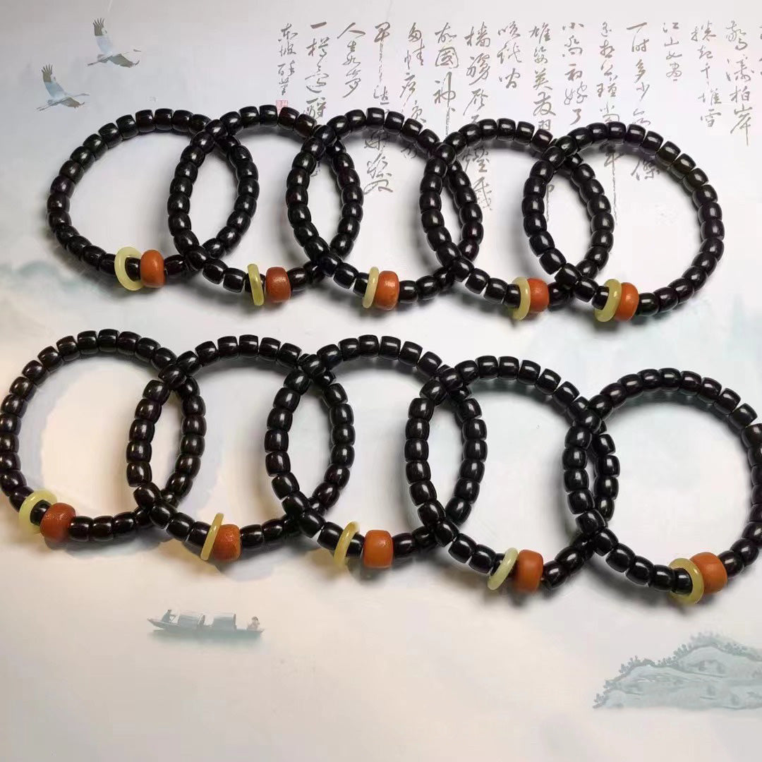 Collection of black coconut shell barrel bead bracelets with red-yellow accents | DIY Jade