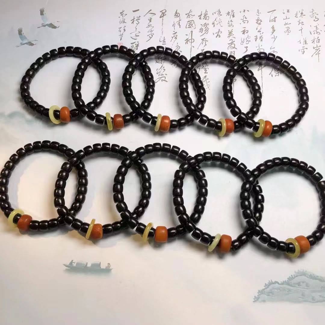 Collection of black coconut shell barrel bead bracelets with red-yellow accents | DIY Jade
