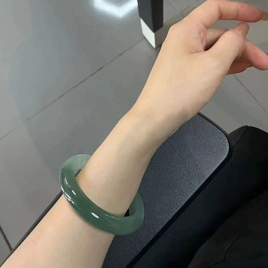 Natural dark green jadeite bangle bracelet worn on wrist at desk, everyday lifestyle shot | DIY Jade