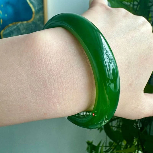 Deep green jade bangle side view worn on wrist, showing glossy surface texture | DIY Jade