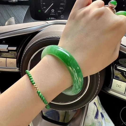 Natural emerald green jadeite bangle bracelet worn on wrist, lifestyle shot in car interior | DIY Jade