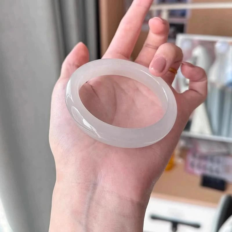 Natural icy white translucent jade bangle held in hand, showing smooth glossy finish | DIY Jade