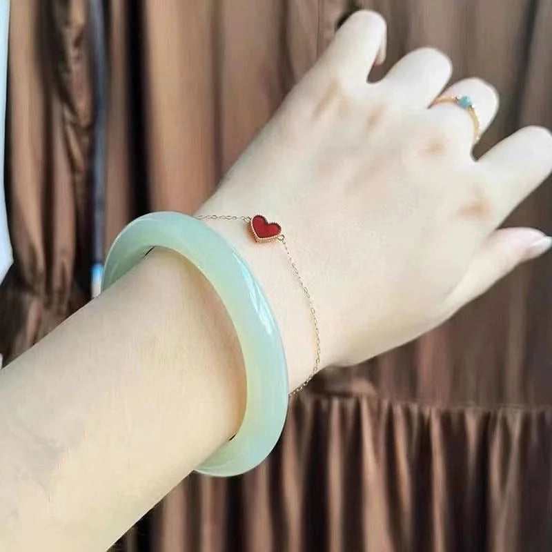 Soft light green jade bangle worn with gold heart bracelet, elegant everyday styling shot | DIY Jade