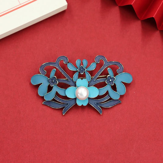 Inspired by the traditional Chinese phoenix, this brooch uses enamel craftsmanship to outline a vivid phoenix. Its blue-purple wings are layered, and two lustrous pearls add a touch of elegance. 01
