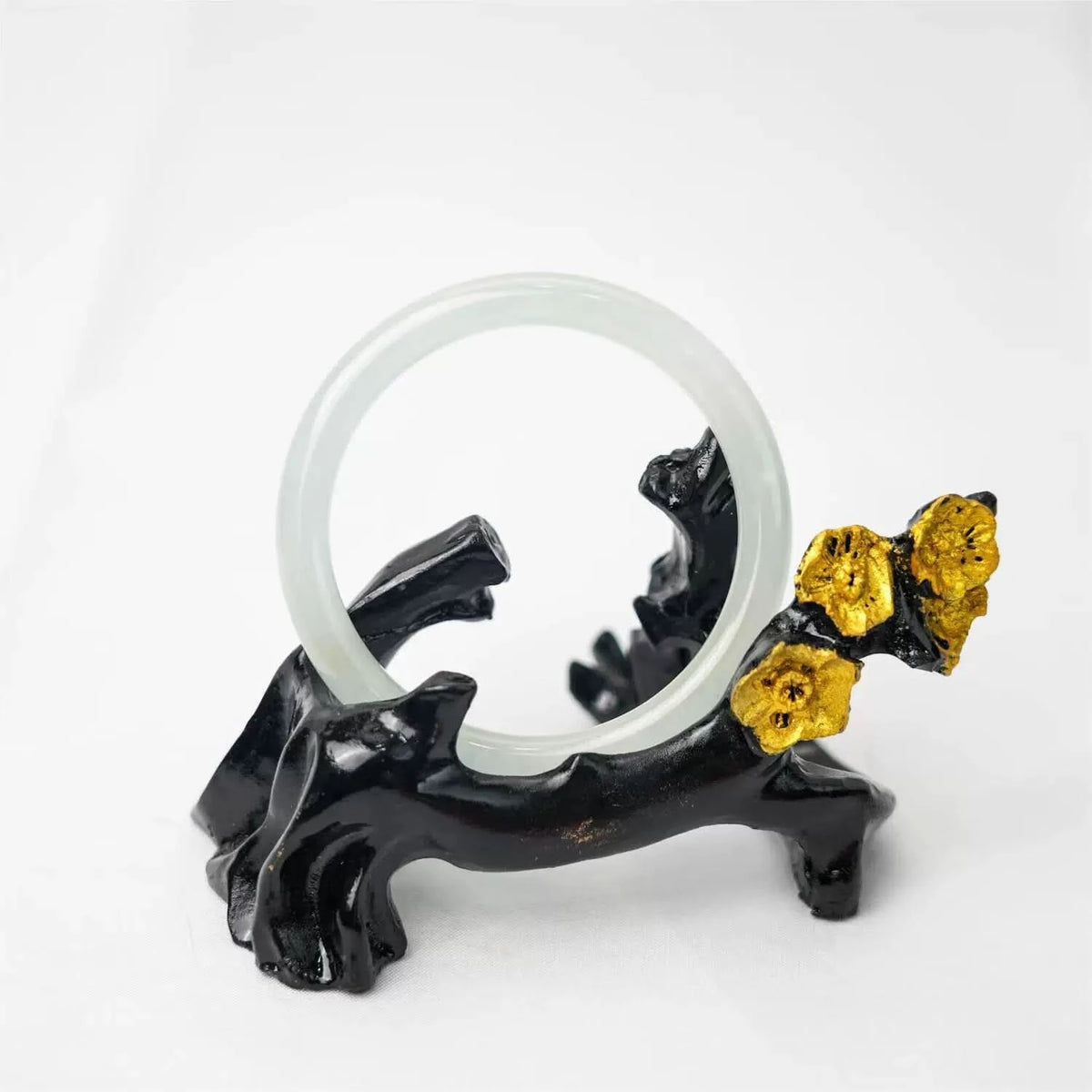 Pale green jade bangle displayed on black floral stand, elegant aesthetic shot | DIY Jade