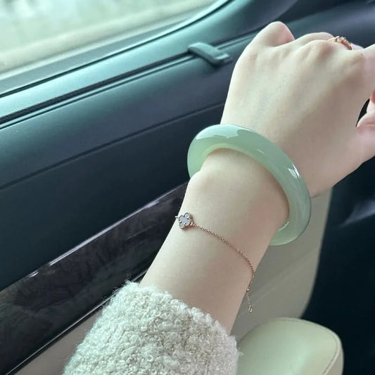 Pale green jadeite bangle worn on wrist in car, elegant everyday lifestyle shot | DIY Jade