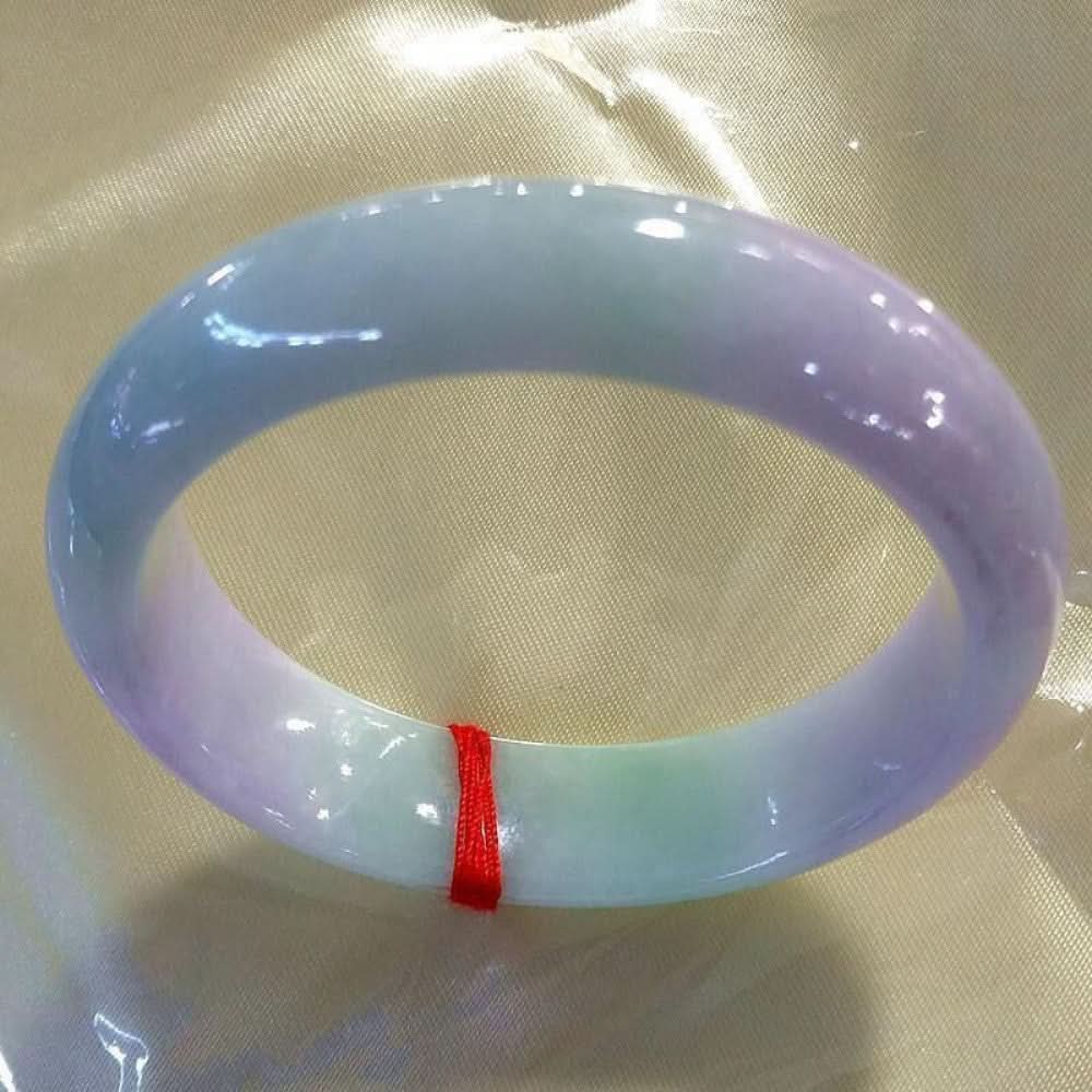 Pastel purple green white jade bangle with red string, smooth glossy finish on silk background | DIY Jade