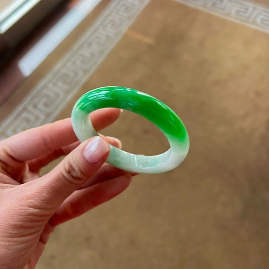 Top bright green and bottom white jadeite bangle held in hand, showing elegant round shape | DIY Jade