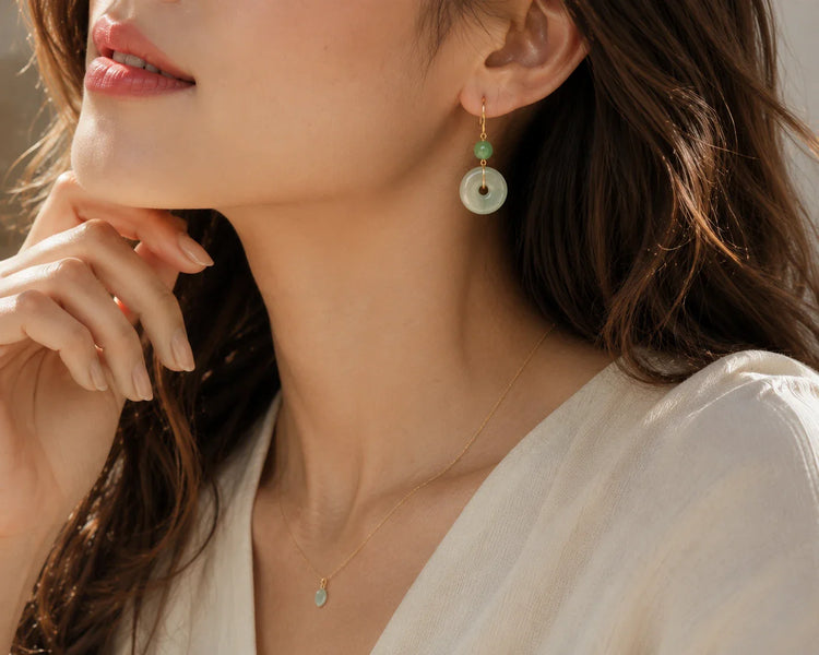 Close-up of a North American woman wearing elegant DIYJADE green jade earrings and matching pendant necklace, softly lit to highlight the natural jade texture and gold accents, perfect for stylish jewelry promotion.