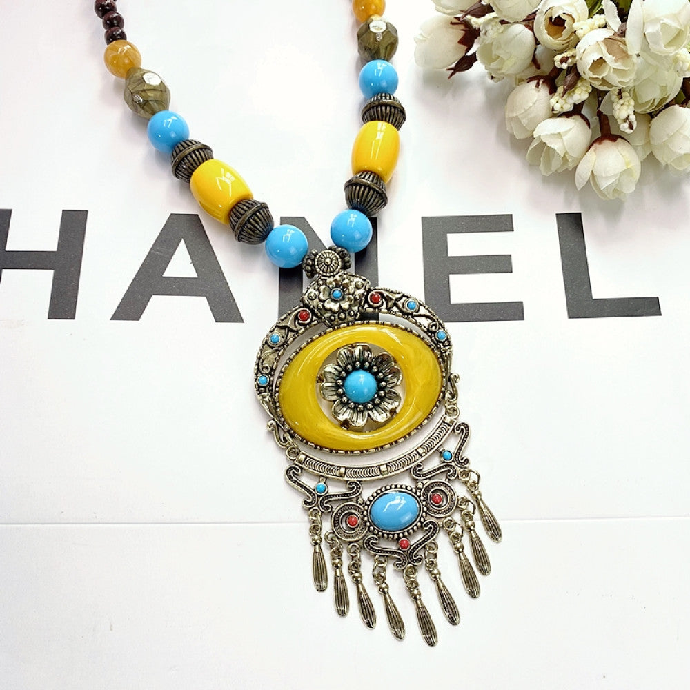 Vintage bohemian ethnic necklace with large red pendant, turquoise details, and tassel design, featuring antique bronze finish, ideal for boho fashion, displayed with floral and text accents against a white background 08