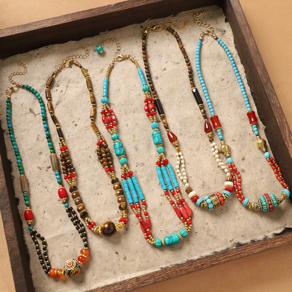 Assorted bohemian ethnic tribal vintage necklace set with colorful beaded designs, featuring turquoise, red, and multi-color beads, displayed in a wooden tray for boho fashion enthusiasts
