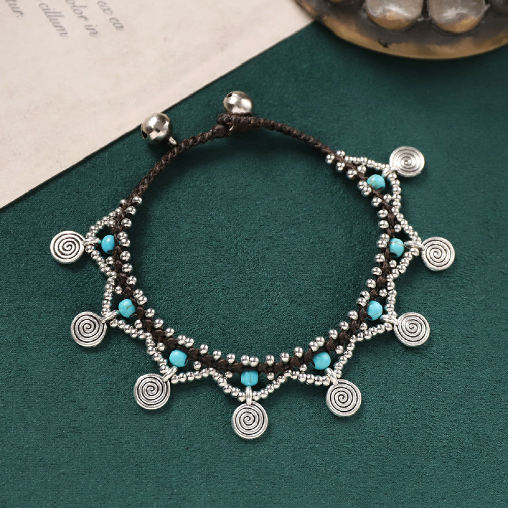 Intricate woven cord with silver discs and turquoise beads, vintage ethnic charm.