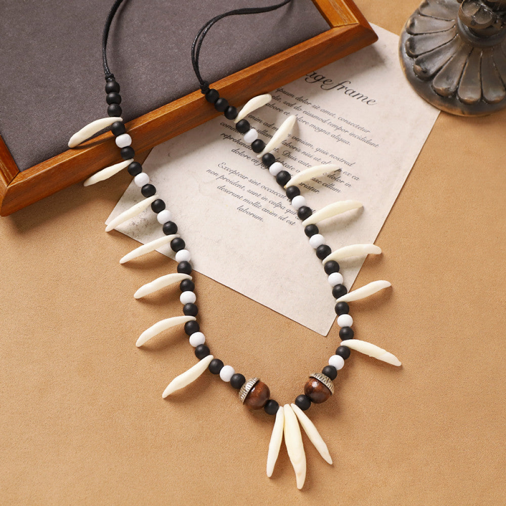 Vintage bohemian tribal necklace with bone accents, black beads, and intricate design, displayed on vintage paper, ideal for ethnic wilderness and boho fashion 01