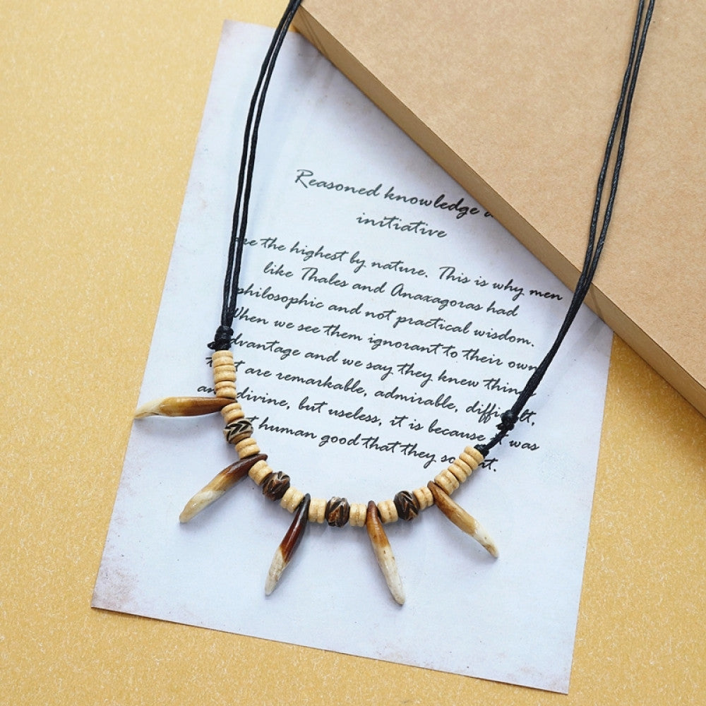 Vintage bohemian tribal necklace with bone accents and black cord, displayed on vintage paper, ideal for ethnic wilderness and boho fashion 01