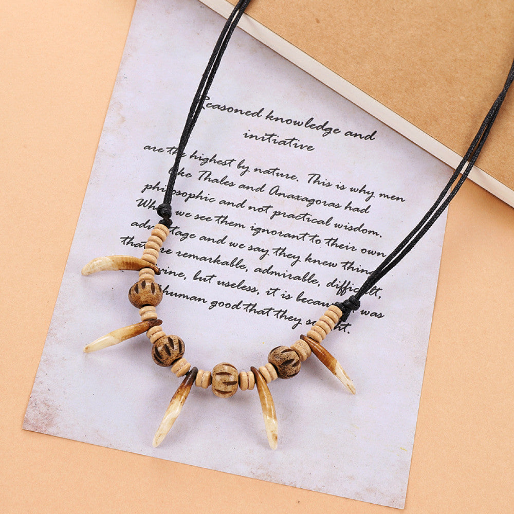 Vintage bohemian tribal necklace with bone accents and black cord, displayed on vintage paper, ideal for ethnic wilderness and boho fashion 03