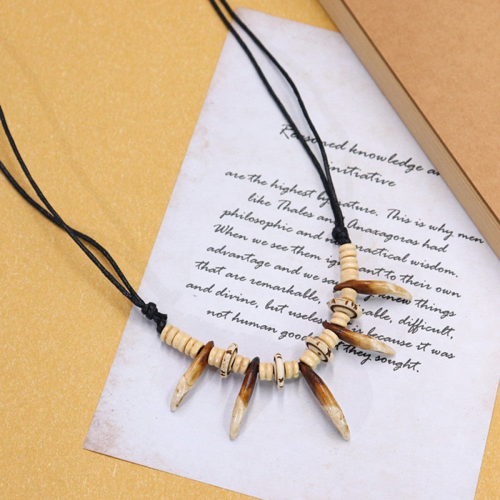 Vintage bohemian tribal necklace with bone accents and black cord, displayed on vintage paper, ideal for ethnic wilderness and boho fashion 06