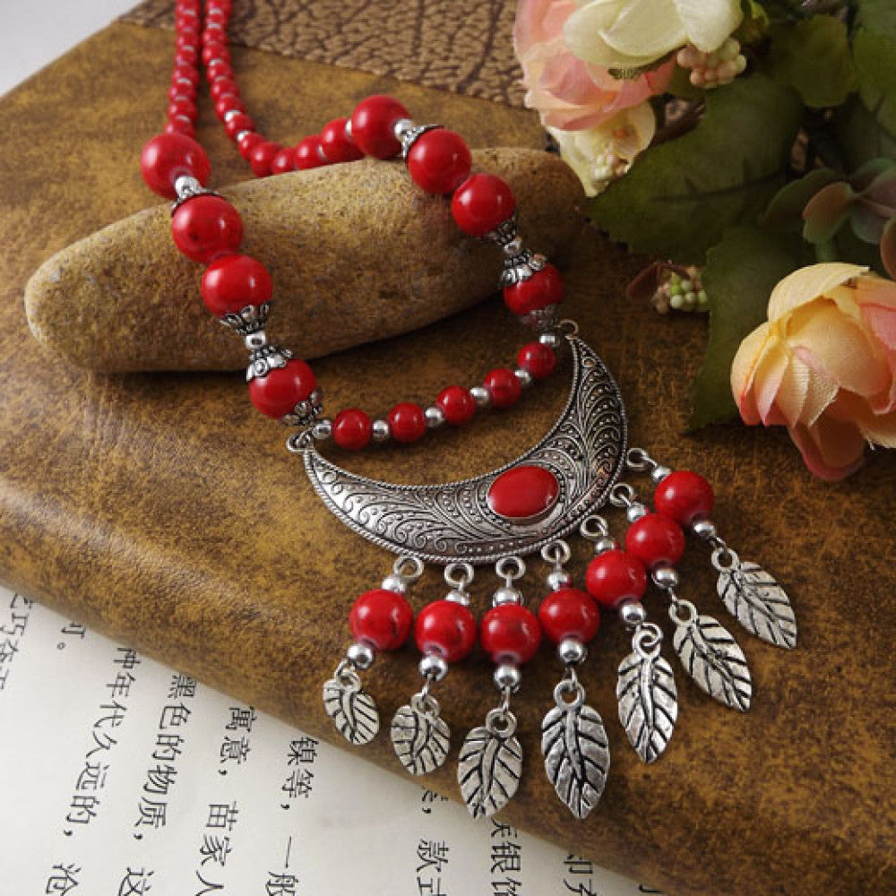 Vintage black beaded necklace with intricate silver-toned leaf tassel and crescent pendant, featuring black beads and gothic tribal design, ideal for bohemian goth fashion, showcased on a textured surface with vintage accents 01
